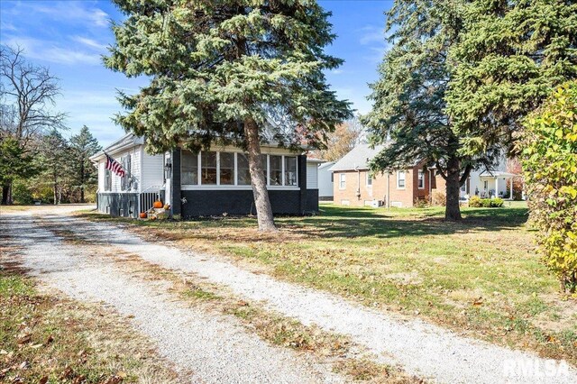 obstructed view of property with driveway and a front lawn