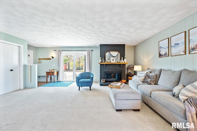 living room with a brick fireplace, light carpet, and a textured ceiling