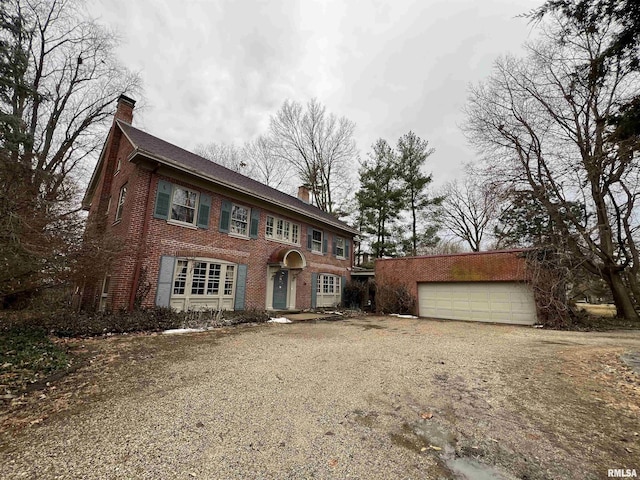 view of front facade with brick siding and a chimney