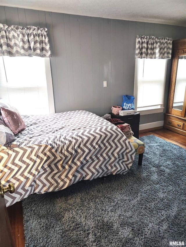 bedroom with a textured ceiling and wood finished floors