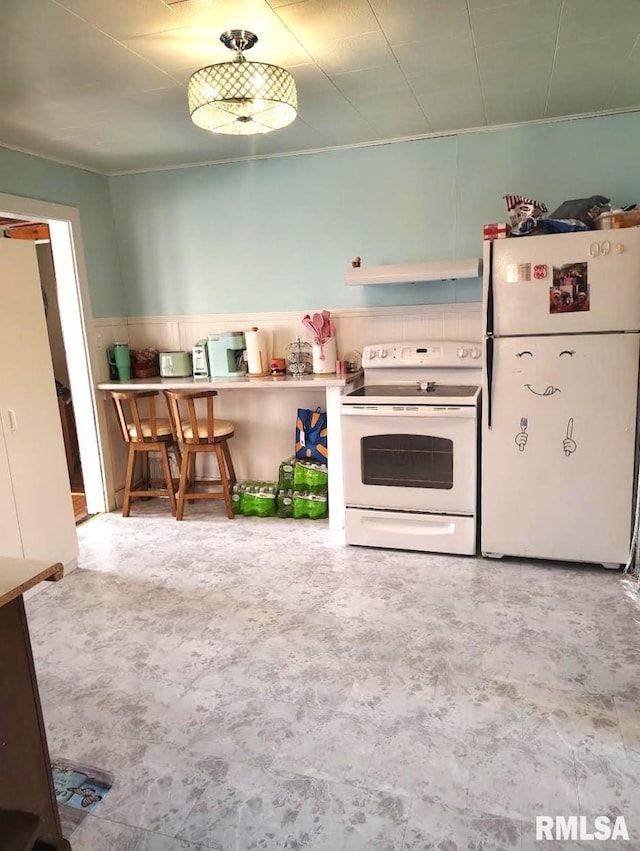 kitchen featuring white appliances and under cabinet range hood