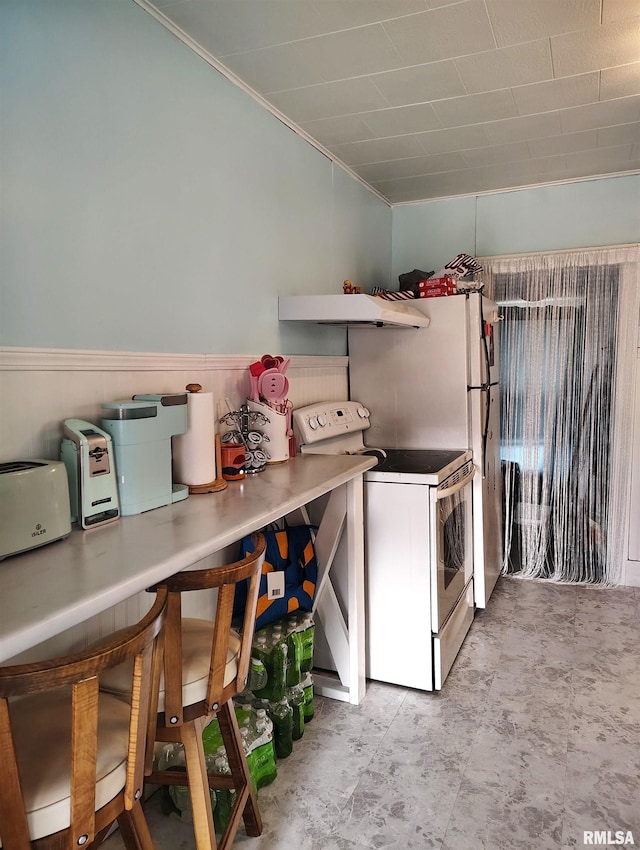 kitchen with white electric stove, wainscoting, and under cabinet range hood