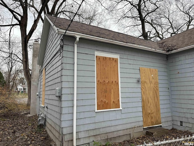 view of side of property featuring roof with shingles