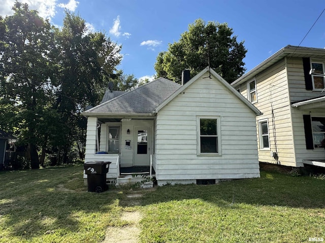 bungalow featuring a front yard and roof with shingles