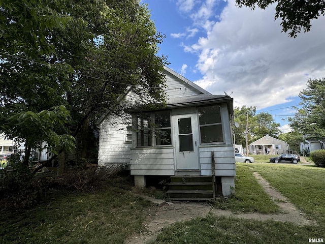 view of front of home with entry steps and a front yard