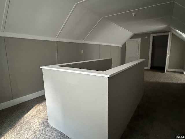 bonus room featuring vaulted ceiling and dark carpet