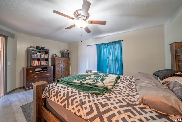 bedroom featuring light wood-style floors, ceiling fan, and a textured ceiling