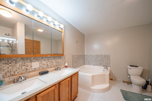 bathroom featuring a garden tub, a sink, backsplash, and toilet