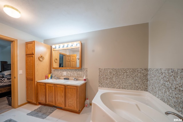 bathroom featuring a garden tub, ensuite bath, tasteful backsplash, and vanity