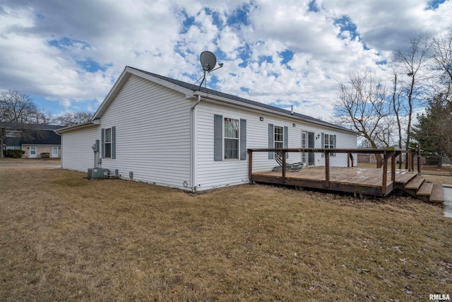 back of property with a lawn, a wooden deck, and central AC unit