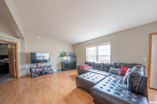 living room featuring vaulted ceiling and light wood-style flooring