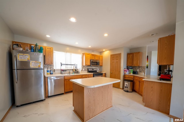 kitchen featuring recessed lighting, stainless steel appliances, a sink, marble finish floor, and light countertops