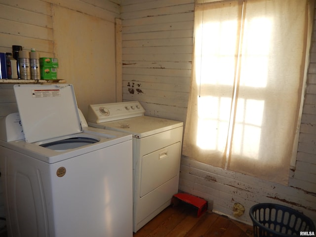 laundry area featuring laundry area, independent washer and dryer, wood walls, and light wood finished floors