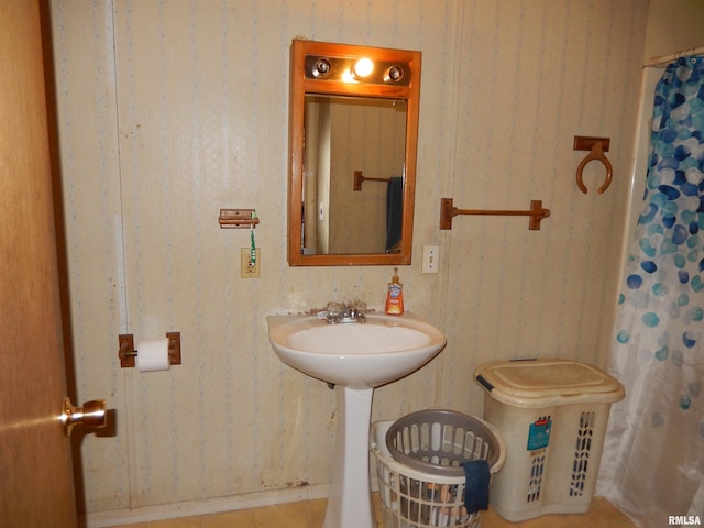 bathroom featuring a sink, curtained shower, tile patterned flooring, and wallpapered walls