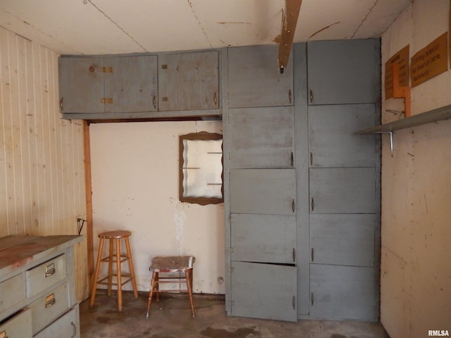 interior space featuring wooden walls and concrete floors