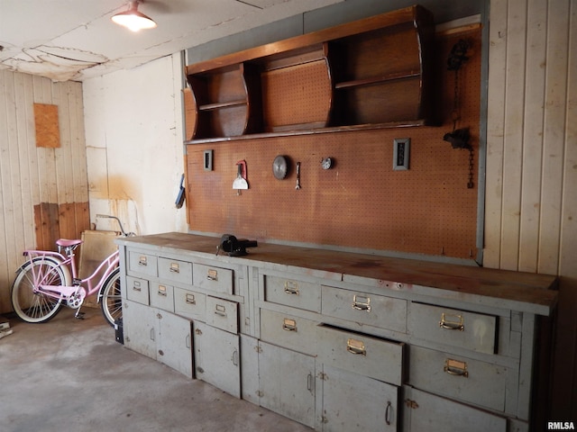 interior space with concrete flooring and wood walls