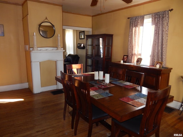 dining space featuring a ceiling fan, ornamental molding, baseboards, and wood finished floors