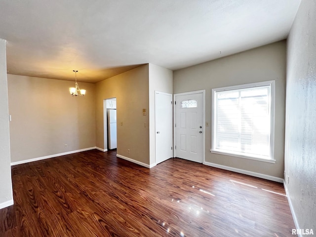 entryway featuring baseboards, wood finished floors, and an inviting chandelier