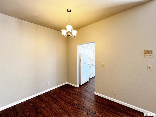 empty room with dark wood-type flooring, a notable chandelier, and baseboards