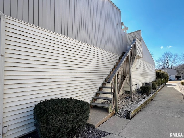 view of side of property featuring central air condition unit and stairs