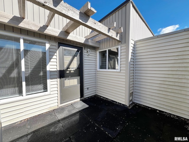 view of exterior entry with board and batten siding