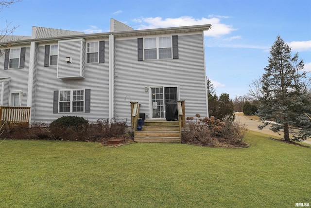 rear view of property featuring a lawn