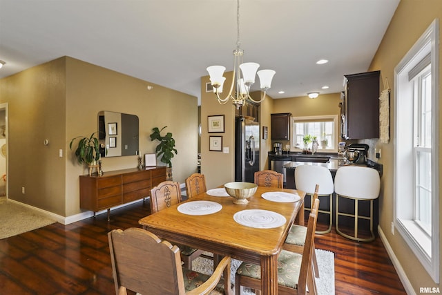 dining room with baseboards, recessed lighting, wood finished floors, and an inviting chandelier