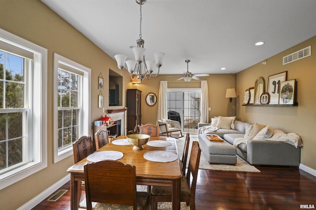 dining room with plenty of natural light, visible vents, dark wood finished floors, and a tiled fireplace