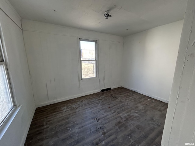 empty room with baseboards and dark wood-style flooring