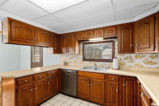 kitchen featuring light countertops, dishwasher, a sink, and wallpapered walls