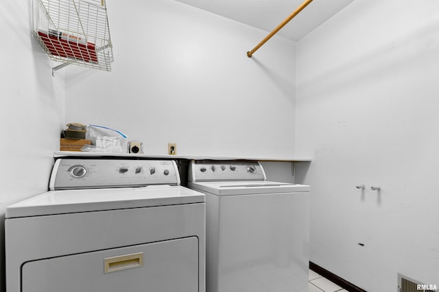 clothes washing area with laundry area, baseboards, visible vents, and independent washer and dryer