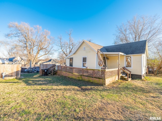 view of property exterior featuring roof with shingles, fence, and a yard