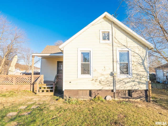 rear view of property with a yard, a shingled roof, and fence