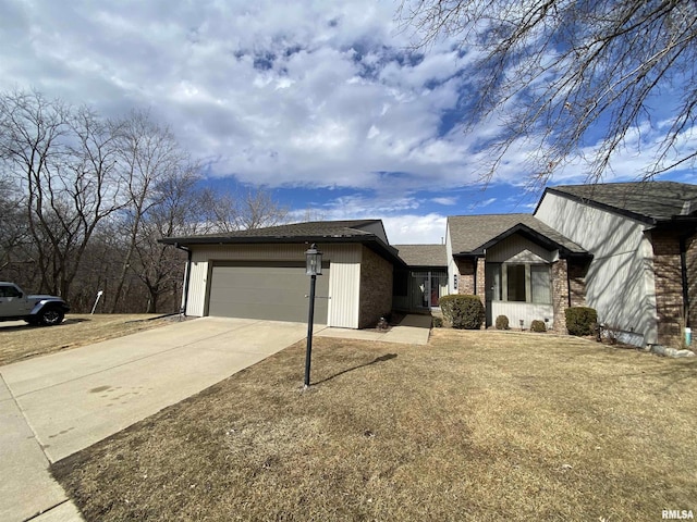 view of front of house with a garage, driveway, brick siding, and a front lawn