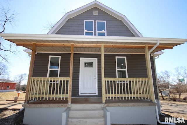 view of front of house with covered porch and a gambrel roof