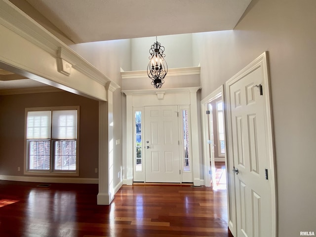 foyer entrance featuring a high ceiling, wood finished floors, visible vents, and baseboards