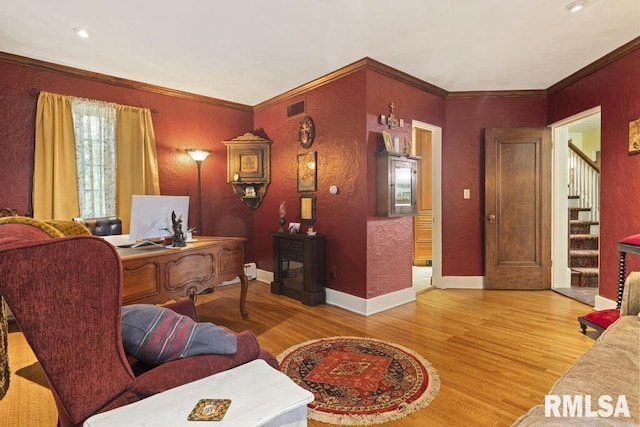 office space with wood finished floors, visible vents, and crown molding