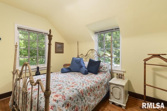 bedroom with dark wood-style floors, vaulted ceiling, and baseboards