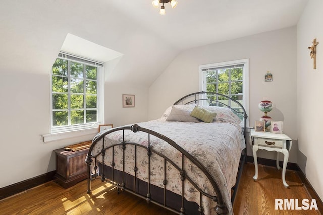 bedroom with lofted ceiling, baseboards, and wood finished floors