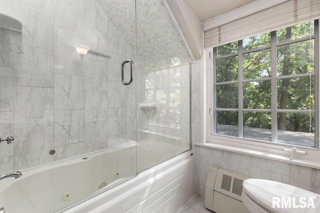 full bath with tile walls, a combined bath / shower with jetted tub, toilet, and a healthy amount of sunlight