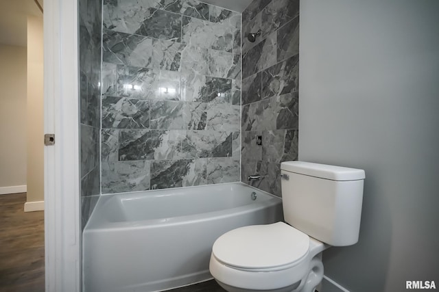 bathroom with toilet, baseboards, wood finished floors, and shower / bathing tub combination