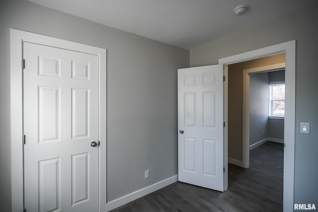 unfurnished bedroom featuring dark wood-style floors and baseboards