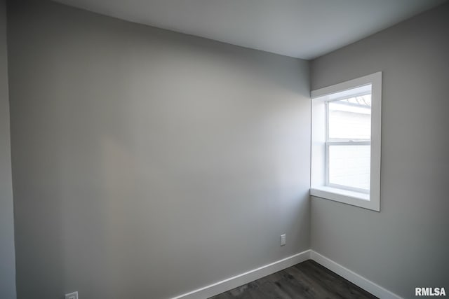 empty room with baseboards and dark wood-style flooring