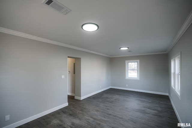 unfurnished room featuring baseboards, visible vents, dark wood-style flooring, and crown molding