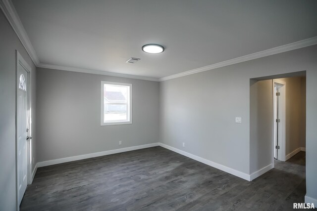 spare room featuring ornamental molding, dark wood-style flooring, and baseboards