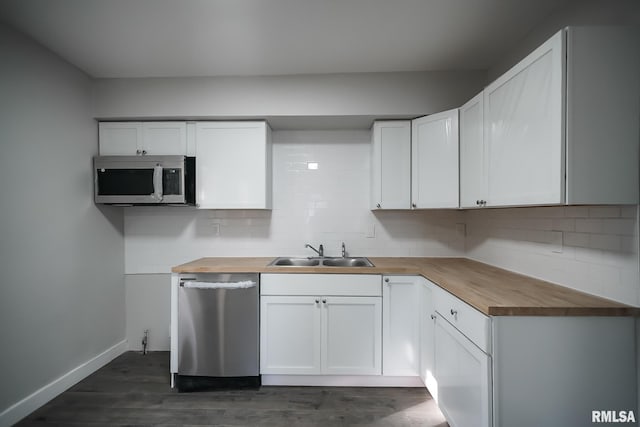 kitchen featuring stainless steel appliances, butcher block counters, a sink, and tasteful backsplash