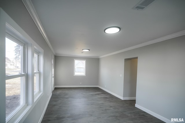 spare room featuring crown molding, dark wood finished floors, visible vents, and baseboards