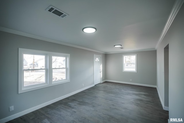 spare room featuring baseboards, visible vents, and crown molding