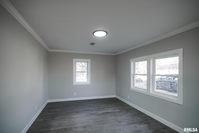 empty room with ornamental molding, dark wood-style flooring, visible vents, and baseboards