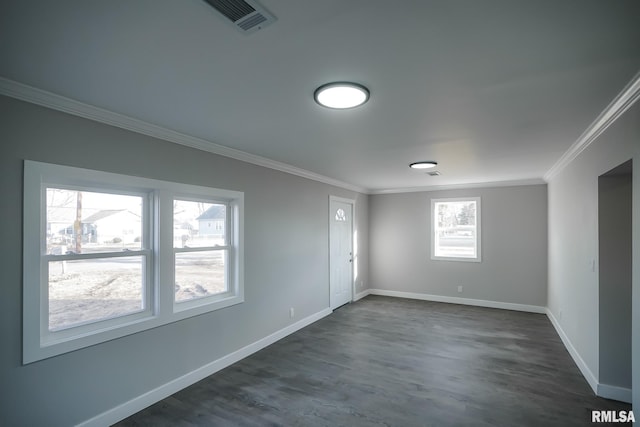 spare room featuring baseboards, dark wood-style floors, visible vents, and crown molding